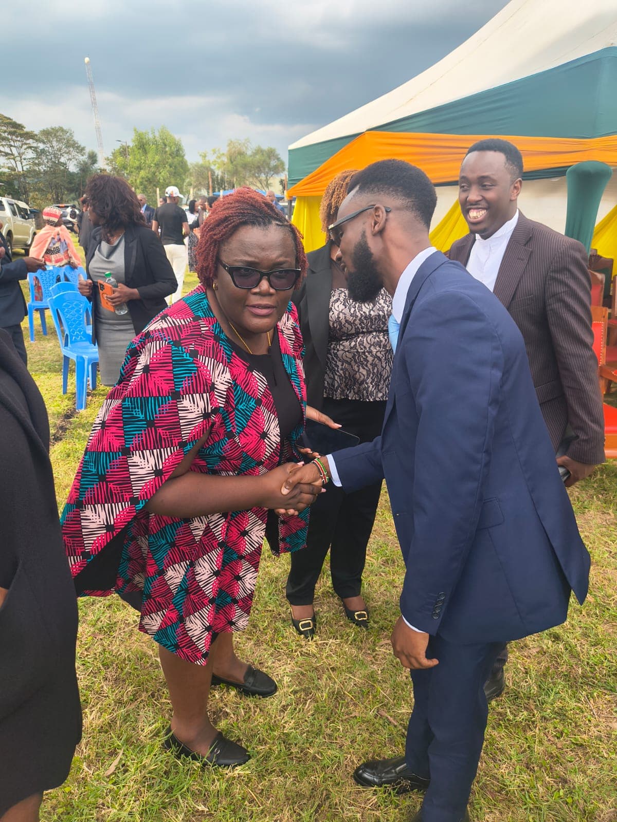 Jacqueline Ingutiah greeting a young advocate at an outdoor event in Bomet